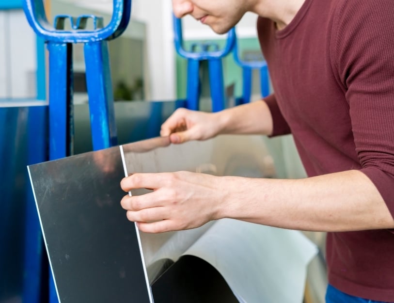 An engineer examines a piece of sheet metal