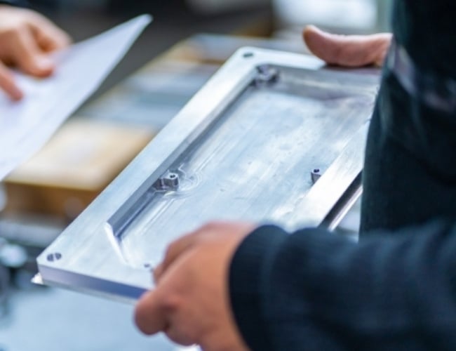 Manufacturing engineer inspects milled steel part