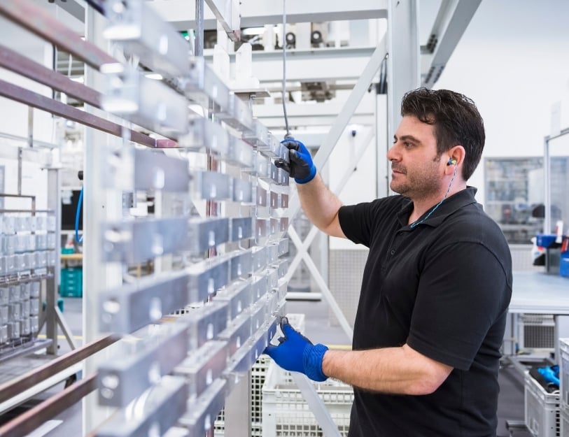 A production specialist prepares parts for anodize