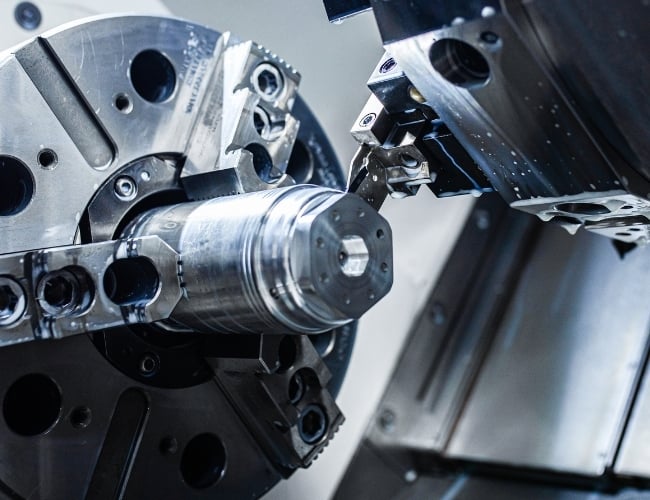 A mill-turn machine cuts a titanium component