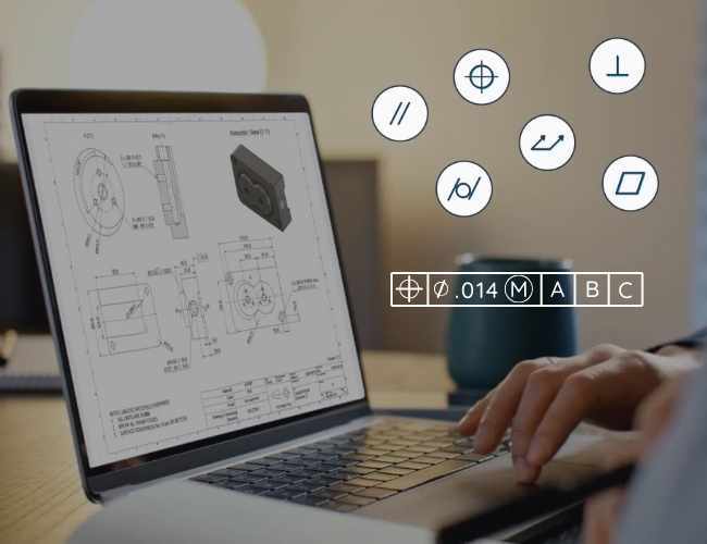 An engineering drawing displayed on a laptop with GD&T symbols and the feature control frame called out