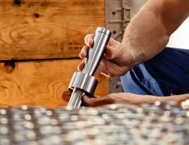 Engineer examines metal shaft made of titanium